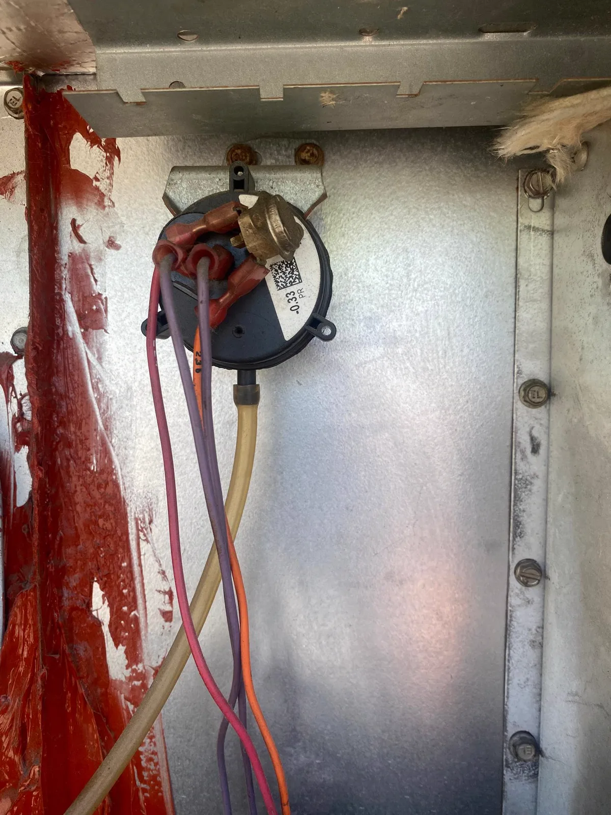 The inside of an equipment cabinet with the panel removed, showing the wiring and a capacitor mounted to the frame.